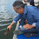 Rinpoche releasing a lobster into the sea