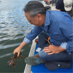Rinpoche releasing a lobster into the sea